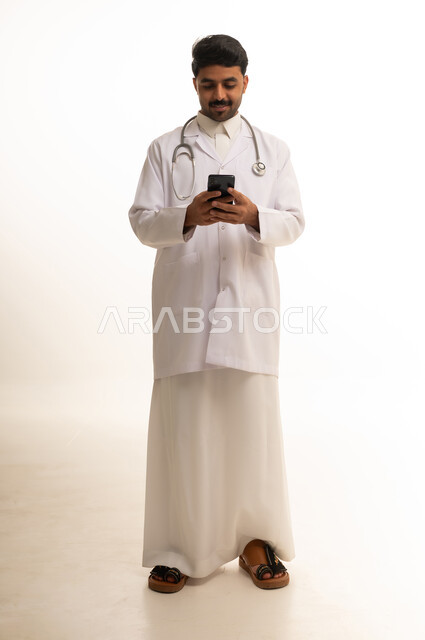 طبيب سعودي يستخدم الهاتف الذكي بخلفية بيضاء