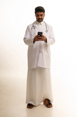 طبيب سعودي يستخدم الهاتف الذكي بخلفية بيضاء