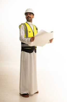 مهندس سعودي بالثوب التقليدي يحمل مخطط بناء معماريا