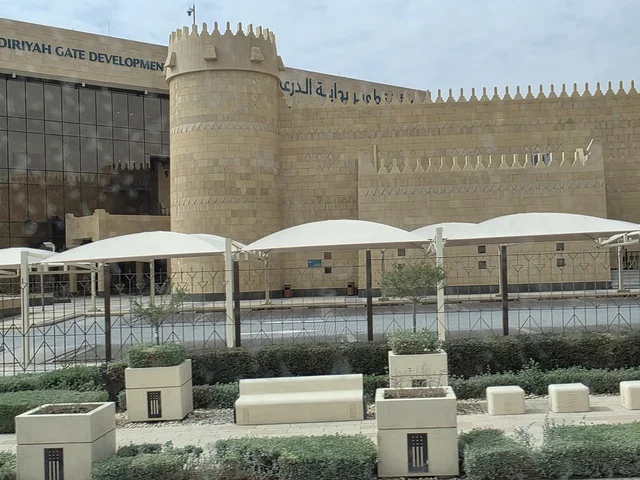 معالم أثرية تاريخية قديمة، أسوار الدرعية القديمة في مدينة الرياض في المملكة العربية السعودية، الفن الهندسي المعماري القديم، المباني الأثرية والبيوت الطينية في حي الطريف في الدرعية، أشجار النخيل الخضراء، مناطق السياحة التراثية في السعودية