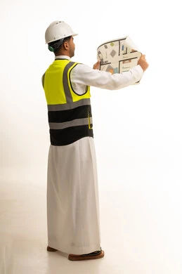 مهندس سعودي يرتدي ملابس السلامة مع مخطط معماري