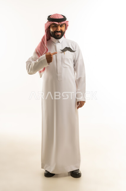 Saudi Man in Traditional Thobe Pointing at Mustache Prop