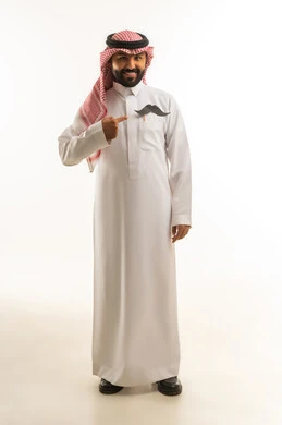 رجل سعودي بالثوب التقليدي يشير إلى شارب ورقي في جيبه