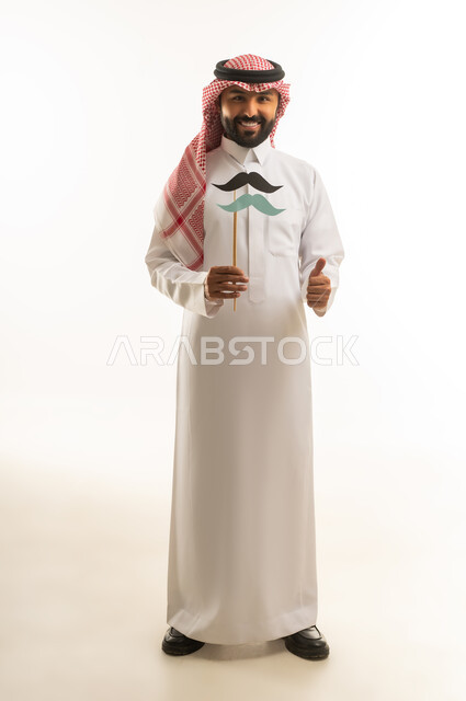 Saudi Man in Traditional Thobe Holding Mustache Prop