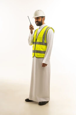 مهندس سعودي يرتدي سترة السلامة مع جهاز لاسلكي