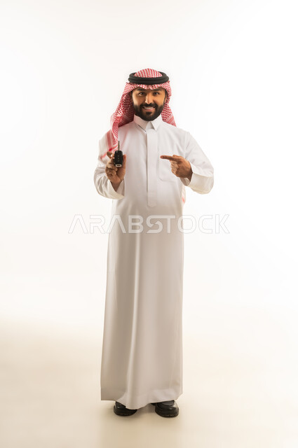 Saudi Man in Thobe Holding Car Key on White Background