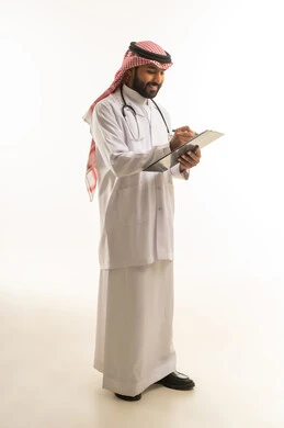 طبيب سعودي يكتب على لوحة ملاحظات بالزي الطبي
