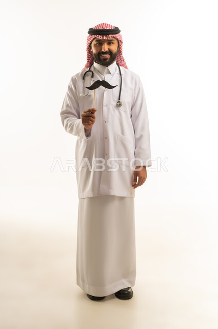 طبيب سعودي بالزي التقليدي مع أداة ترفيهية