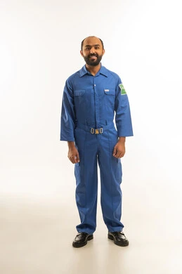 فني سعودي بزي العمل الصناعي الأزرق