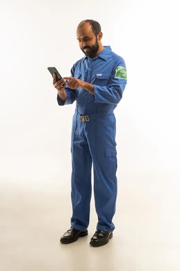 Saudi Technician in Blue Uniform Using Smartphone