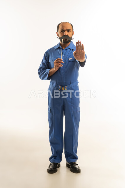 فني سعودي بزي أزرق وإشارة التوقف