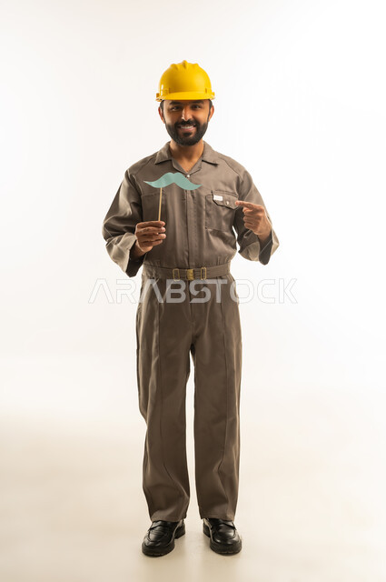 عامل هندي بخوذة صفراء يحمل شارب ورقي