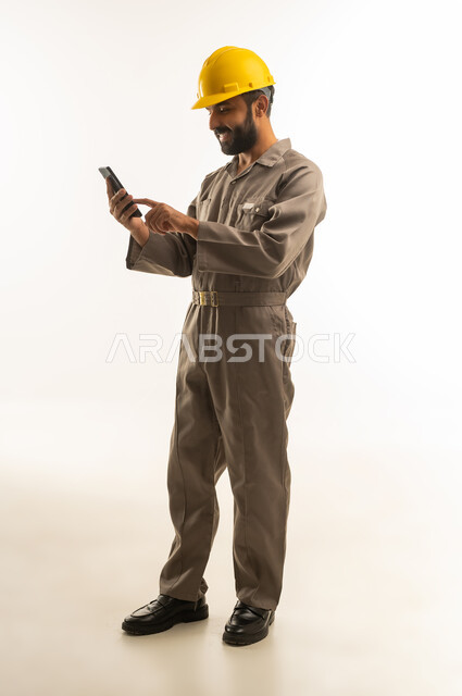 عامل هندي بخوذة سلامة يستخدم الهاتف الذكي