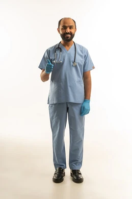 طبيب سعودي يبتسم مع إشارة الإعجاب بالزي الطبي