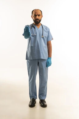 طبيب سعودي بالزي الطبي يشير بعلامة التوقف