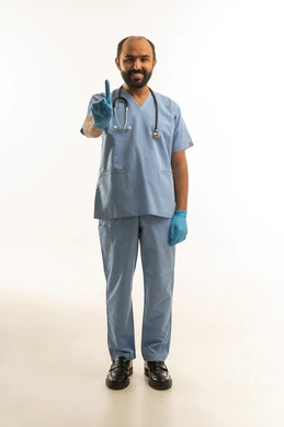 طبيب سعودي بالزي الطبي الأزرق يشير للأعلى