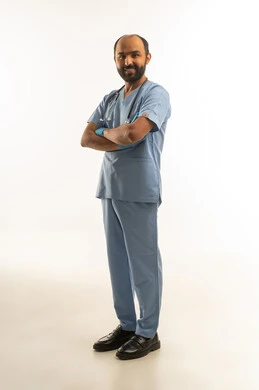 طبيب سعودي بالزي الطبي الأزرق في الاستوديو