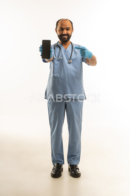 Saudi Male Doctor in Blue Scrubs Holding Smartphone