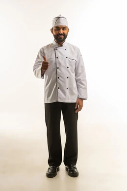 طباخ من جنوب آسيا بالزي الرسمي يرفع إبهامه