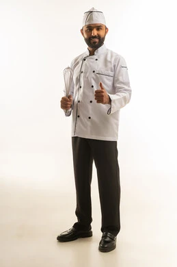 شيف عربي بالزي الأبيض يحمل مخفقة يدوية