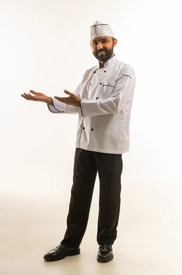 شيف سعودي محترف بزي العمل الأبيض يقدم عرضا