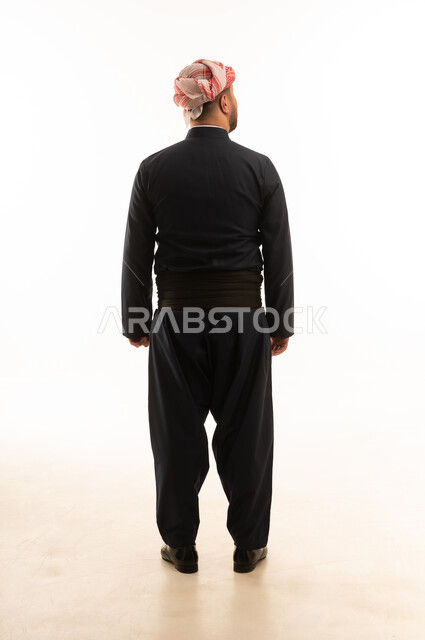 رجل بالزي الكردي التقليدي الأسود من الخلف