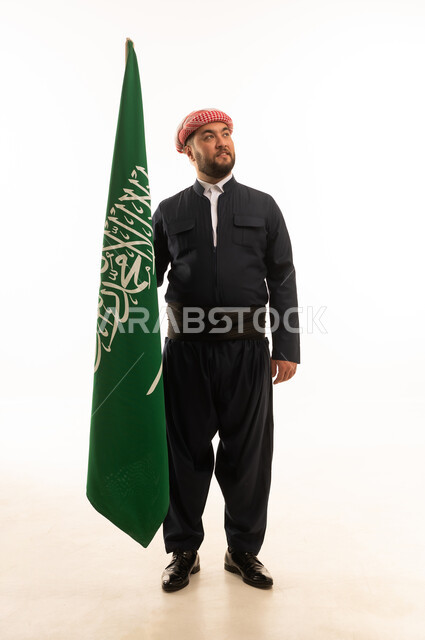 رجل بالزي الكردي يحمل علم المملكة العربية السعودية