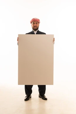 رجل بالزي الكردي يحمل لوحة بيضاء فارغة