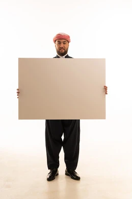 رجل كردي بالزي التقليدي يحمل لوحة بيضاء فارغة