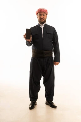 رجل بالزي الكردي التقليدي يحمل هاتف ذكي