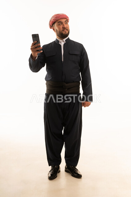 Kurdish Man in Traditional Black Attire with Smartphone