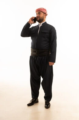 رجل بالزي الكردي التقليدي يتحدث بالهاتف