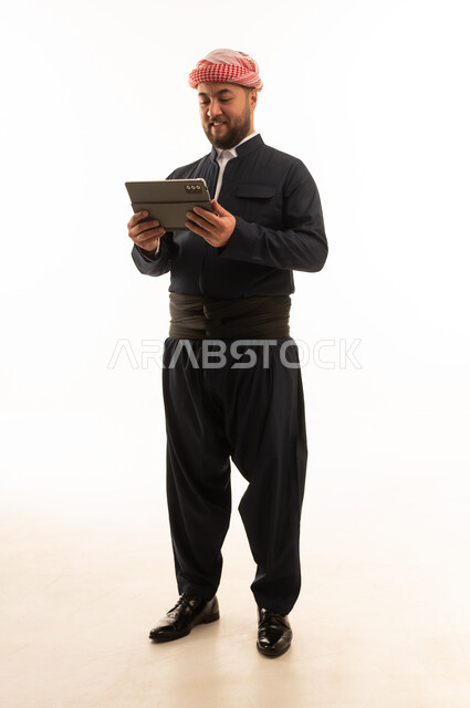 Kurdish Man in Traditional Black Attire Using Tablet