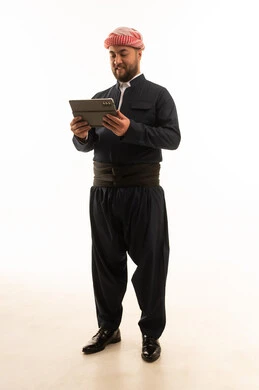 رجل بالزي الكردي التقليدي الأسود يستخدم جهاز لوحي