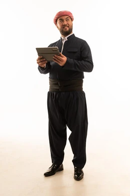 رجل بالزي الكردي التقليدي يستخدم جهاز لوحي رجل بالزي الكردي التقليدي يستخدم جهاز لوحي