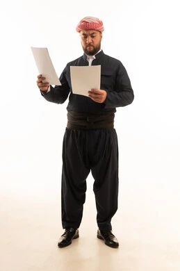 رجل باللباس الكردي التقليدي يقرأ أوراق بخلفية بيضاء