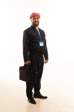 رجل بالزي الكردي التقليدي يحمل حقيبة أعمال