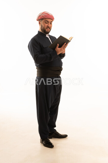 رجل كردي باللباس التقليدي يقرأ كتاباً