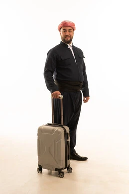 رجل بالزي الكردي التقليدي مع حقيبة سفر