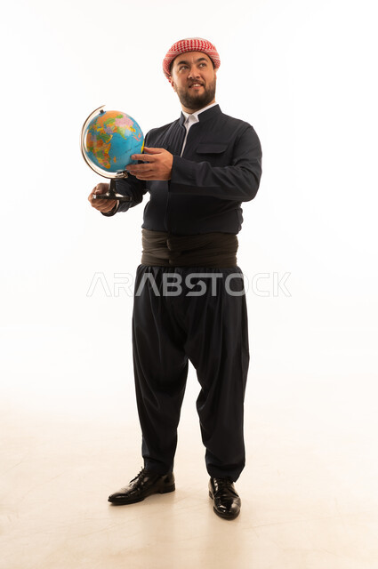 رجل بالزي الكوردستاني التقليدي يحمل الكرة الأرضية