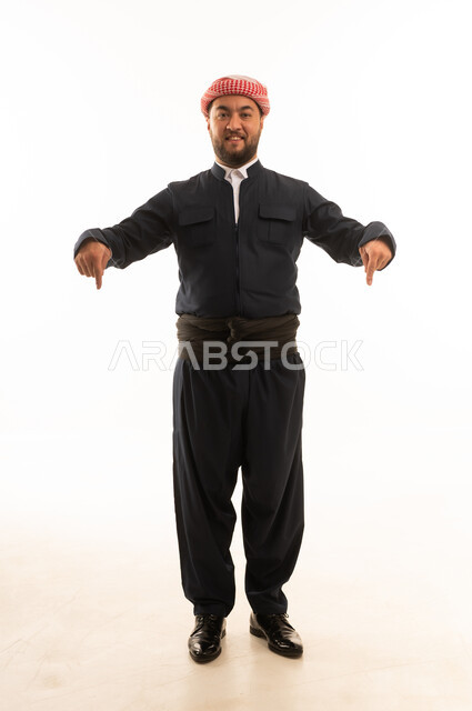 رجل بالزي الكردي التقليدي يشير إلى الأسفل