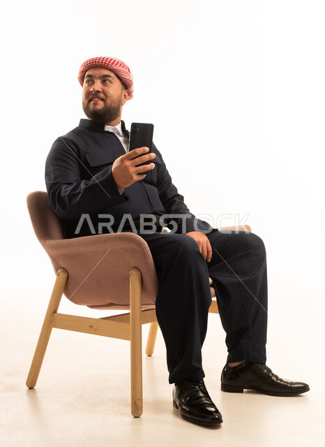 رجل بالزي الكردي التقليدي الأسود يحمل هاتف ذكي