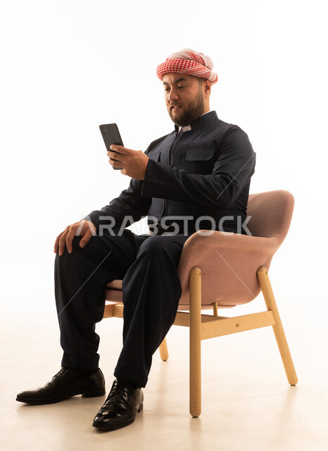 رجل بالزي الكردي والشماغ السعودي يستخدم الهاتف خلفية بيضاء
