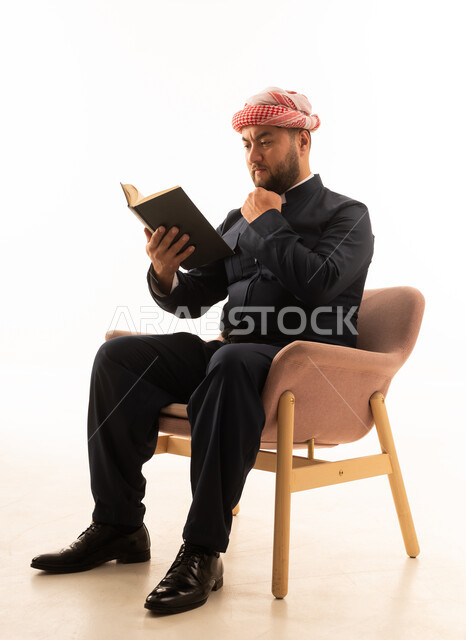 رجل كردي بالزي التقليدي الأسود يقرأ كتاباً