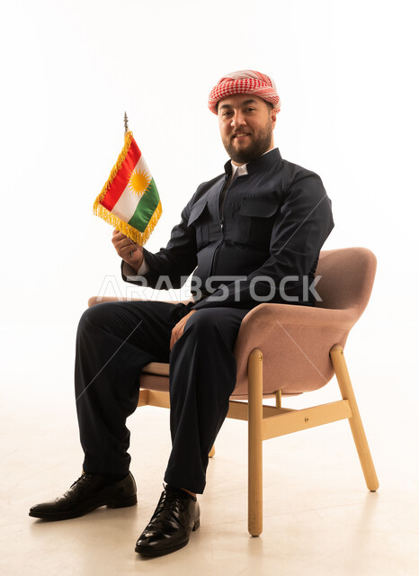 رجل بالزي الكردي التقليدي يحمل علم كردستان