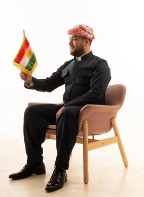 رجل كُردي باللباس التقليدي مع علم كوردستان