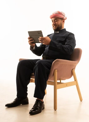 رجل بالزي الكردي يستخدم جهاز لوحي بخلفية بيضاء