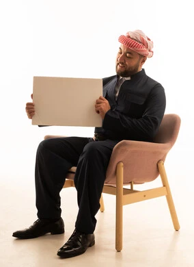 Man in Kurdish Attire and Shemagh Holding White Board