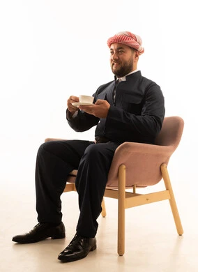 رجل كردي بالزي التقليدي الأسود يشرب القهوة