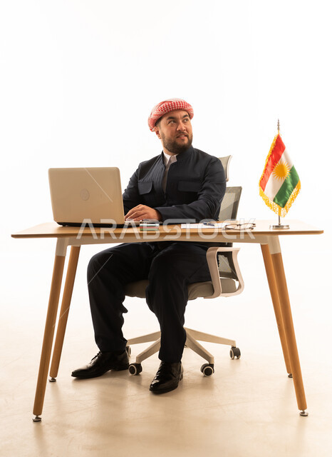 Kurdish Man Working on Laptop at Office Desk